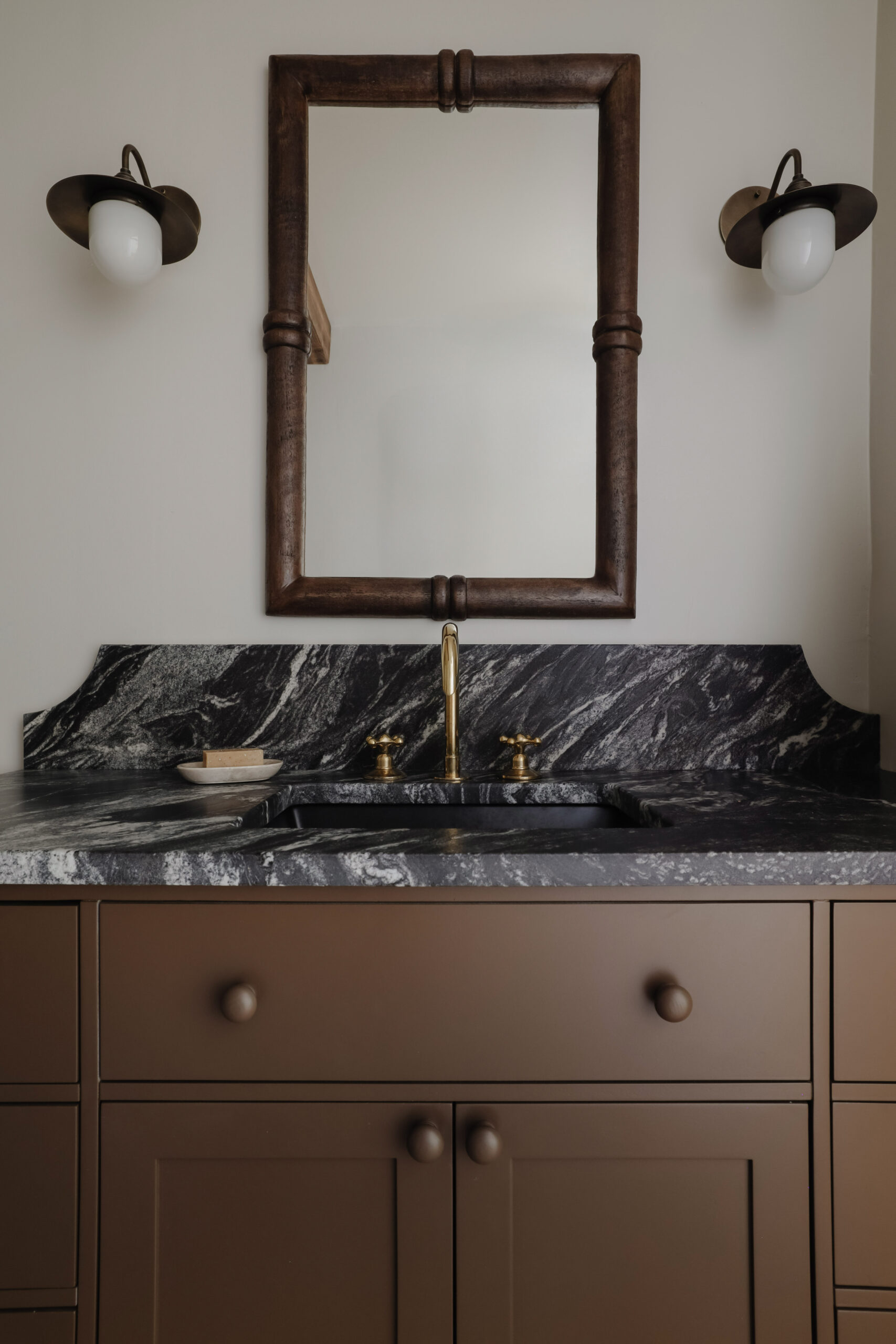 The pros and cons of granite countertops. Are granite countertops out of style? Black granite countertops in a bathroom. Nadine Stay