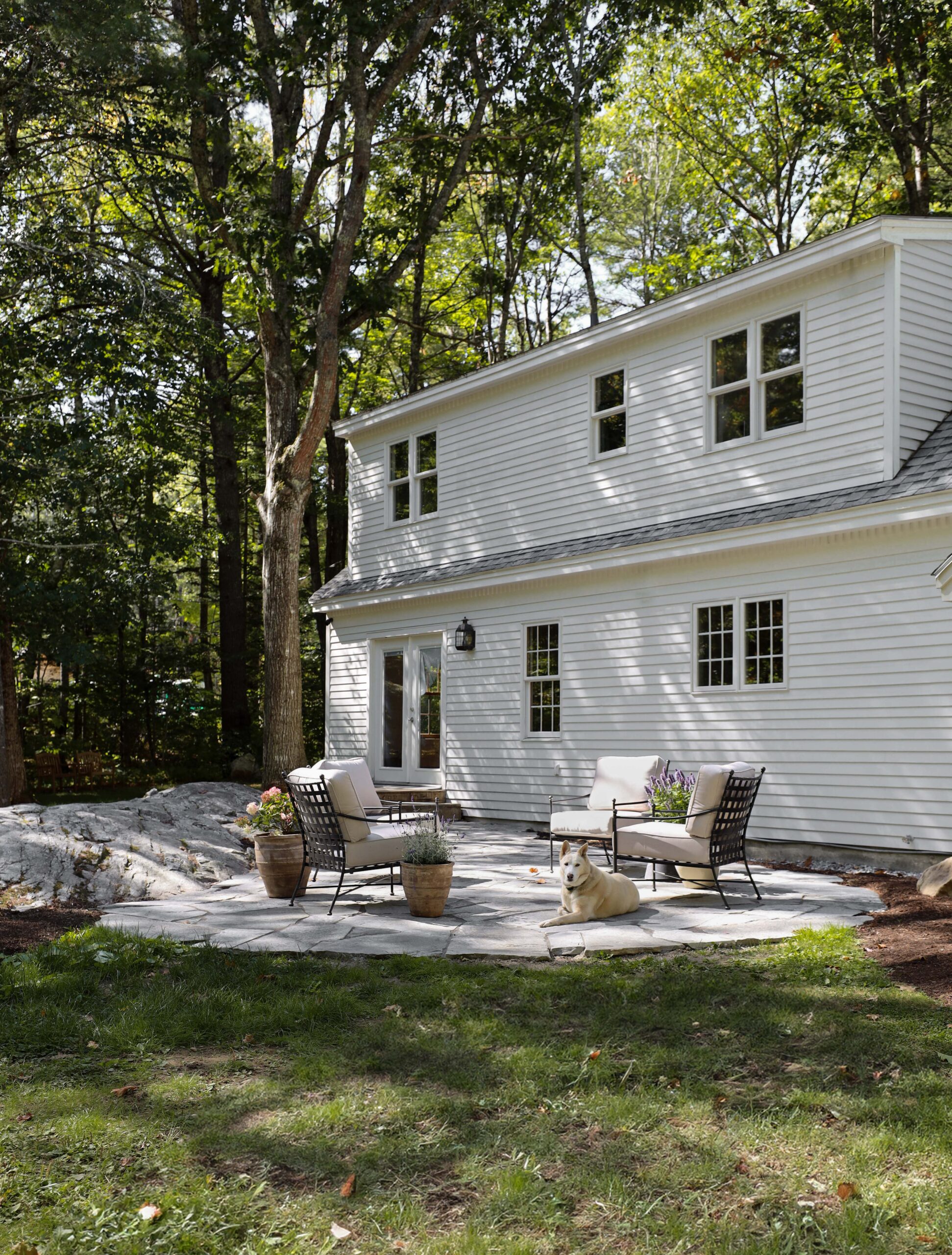 Backyard flagstone patio with iron basketweave patio chairs. Nadine Stay