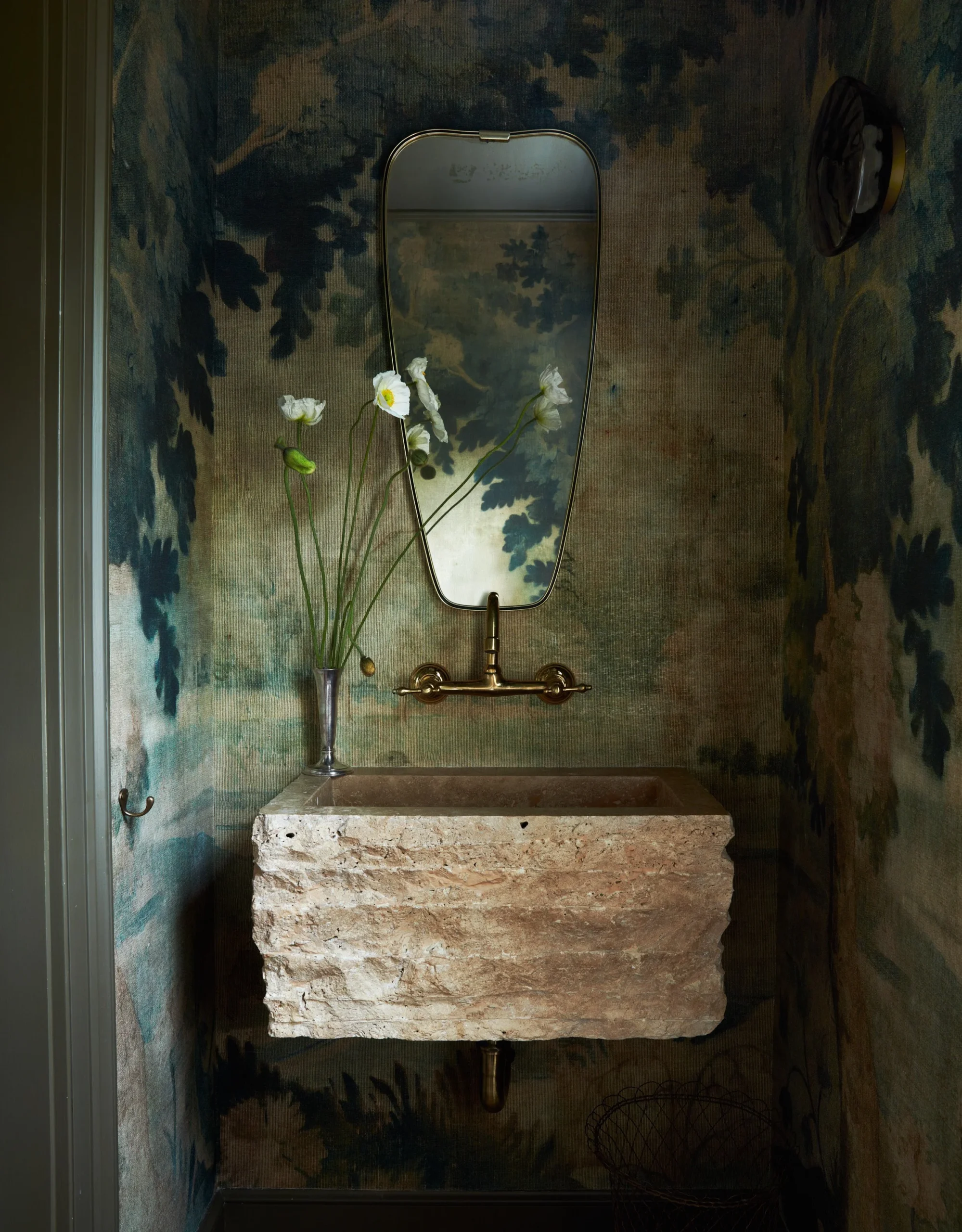 Antique brass faucet and mural floral wallpaper in half bath. Dated metal finishes and alternatives. Moore House Design