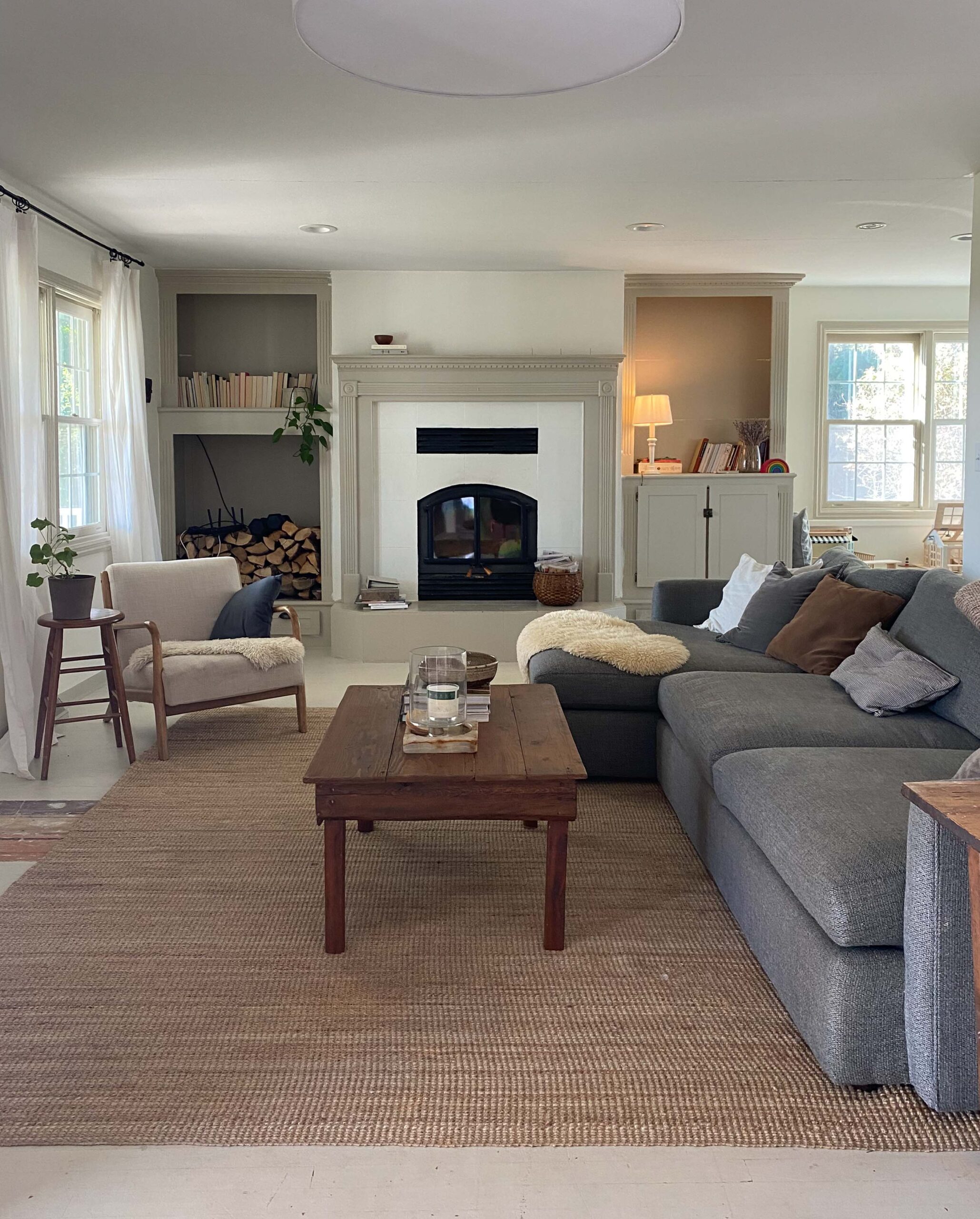 farmhouse living room with raised fireplace and built-ins
