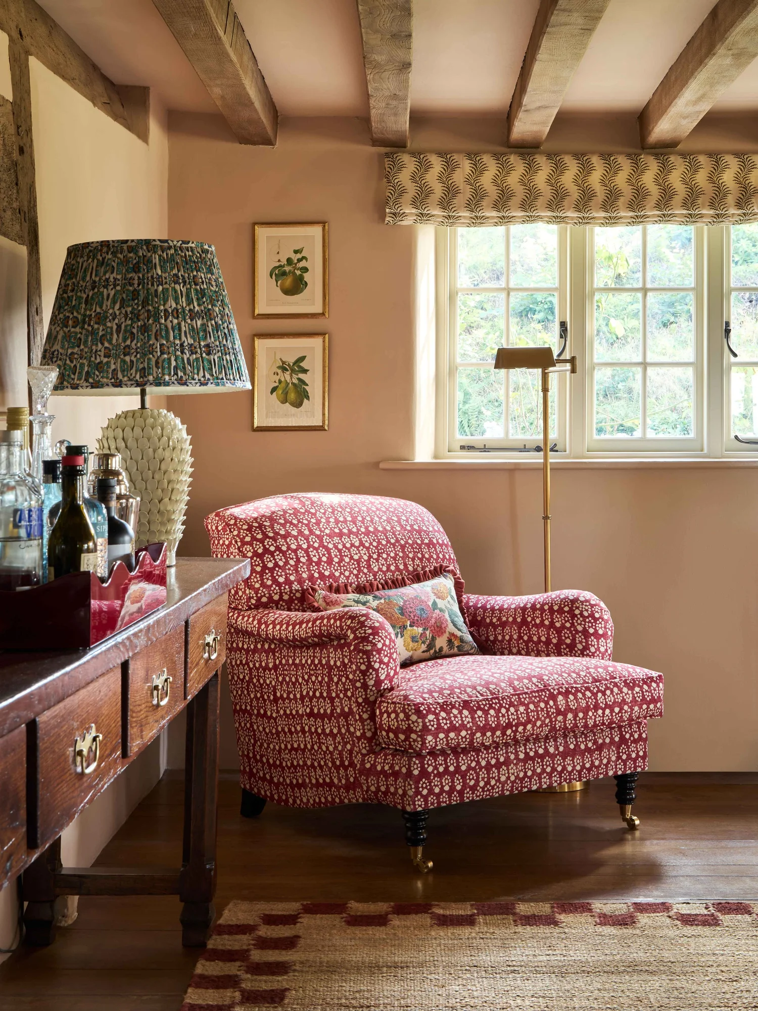 English cottage color drenched in a peach paint color. Red patterned arm chair. Anna Hewitson