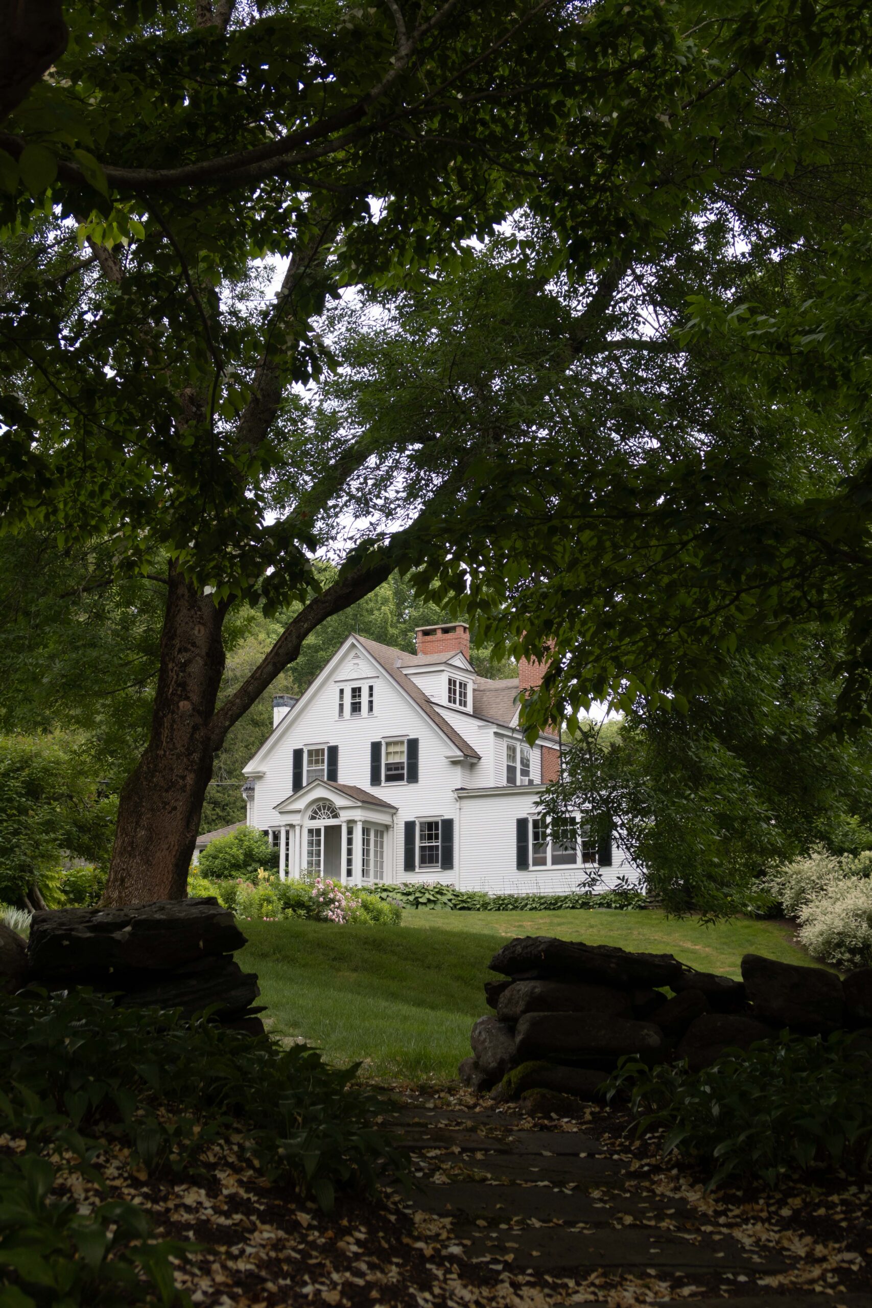 White house with black shutters and glass entry - Nadine Stay