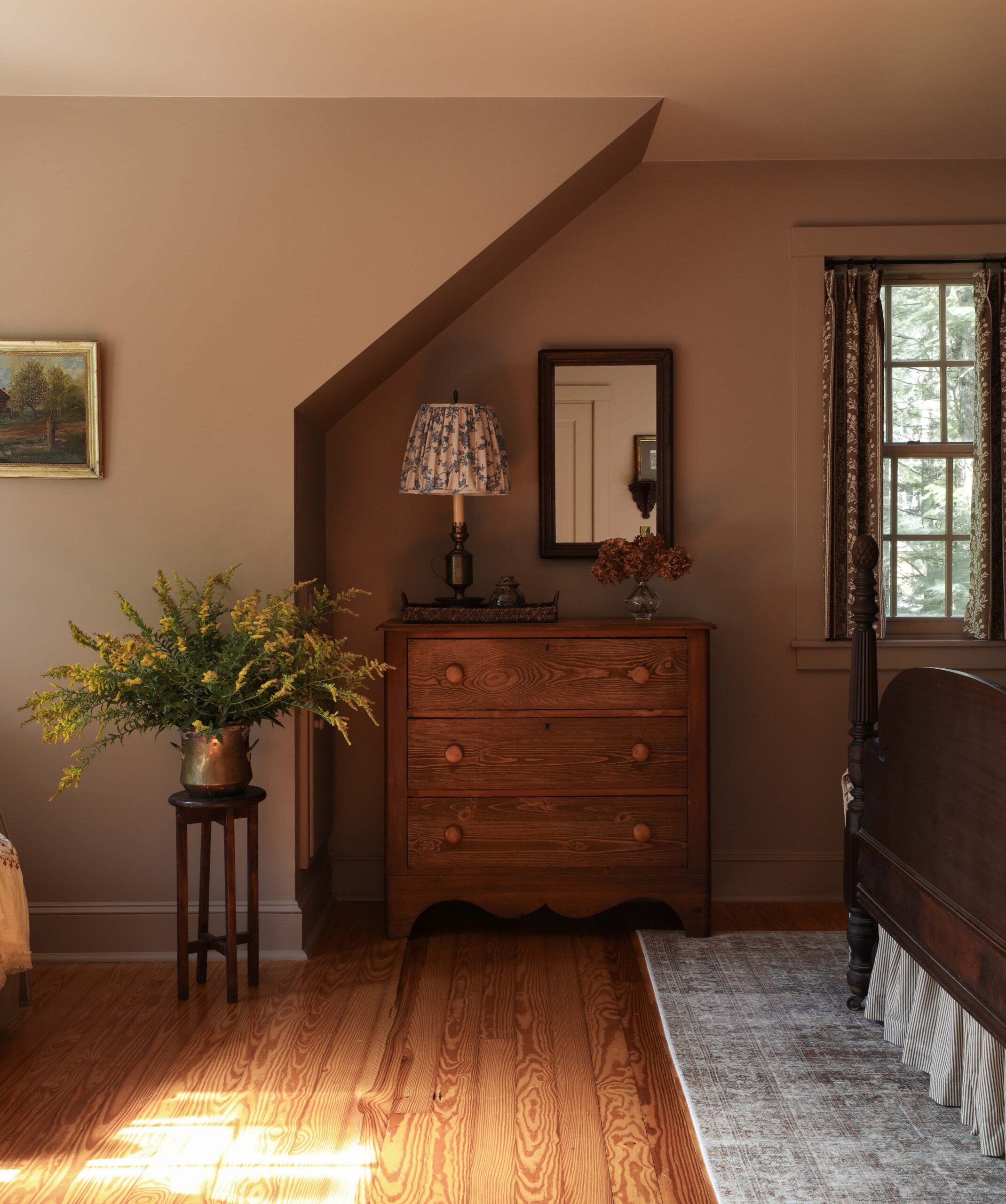 Bedroom painted Dead Salmon by Farrow & Ball. Wood dresser and antique lamp with an antique pineapple bed frame. Nadine Stay
